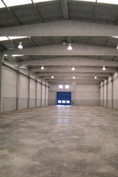 Almacén vacío con puerta industrial azul.png
